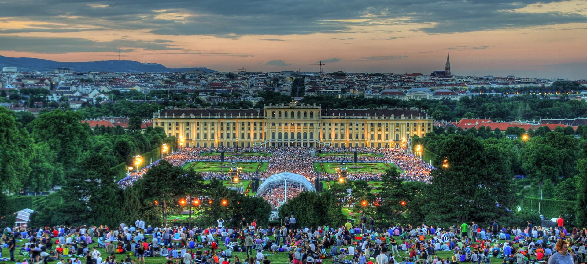 Schönbrunn Palace gardens and Vienna skyline at dusk